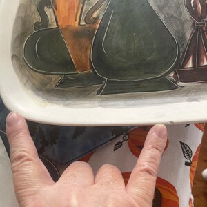 May include: A white ceramic serving tray with a hand-painted design of three vases in shades of brown, green, and black. The vases are stylized and have a modern art aesthetic.