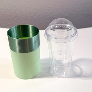 Może przedstawiać: Zestaw trzech ceramicznych kubk&oacute;w z nakrapianym, matowym wykończeniem. Kubki są w odcieniach kremu, jasnoszarym i ciemnoszarym. Każdy ma prosty, minimalistyczny design.