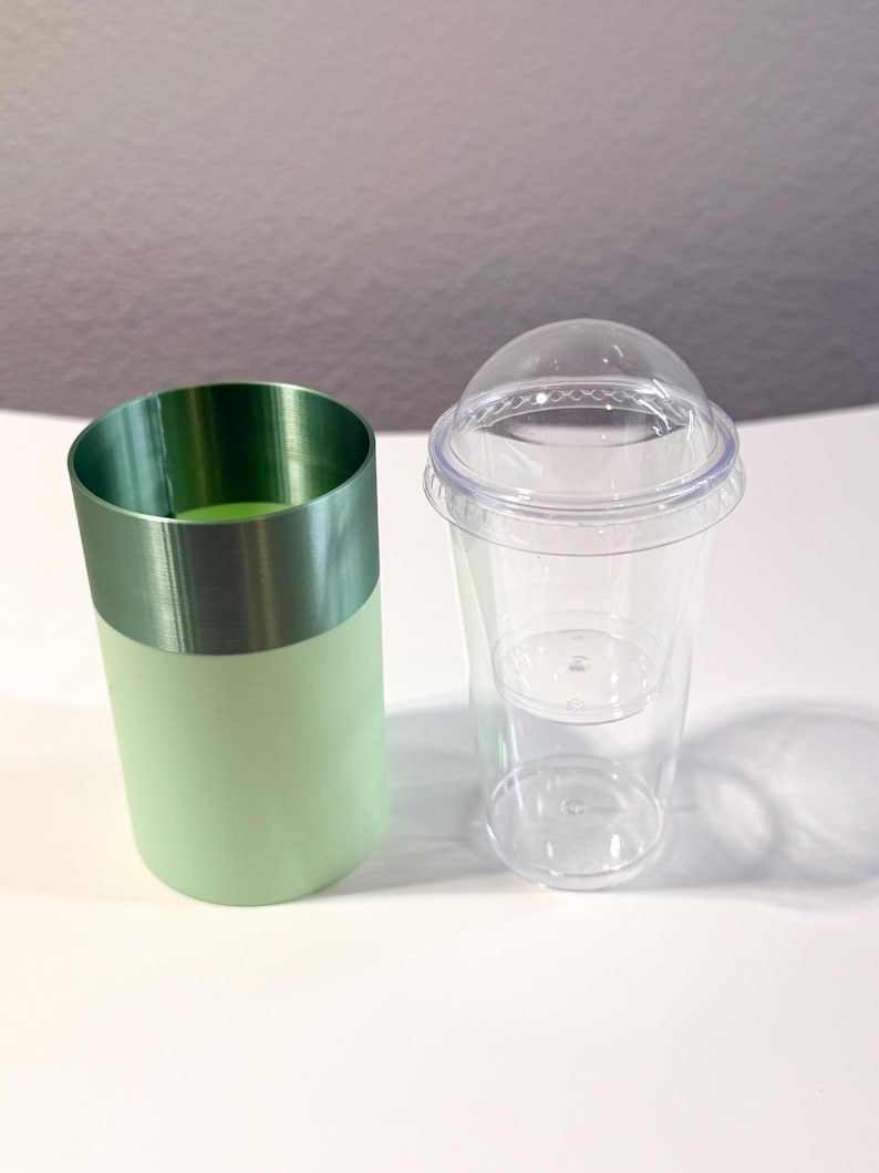 Może przedstawiać: Zestaw trzech ceramicznych kubk&oacute;w z nakrapianym, matowym wykończeniem. Kubki są w odcieniach kremu, jasnoszarym i ciemnoszarym. Każdy ma prosty, minimalistyczny design.