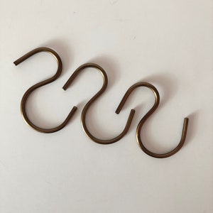 May include: Three gold-toned metal S-shaped hooks.