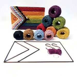 May include: A rainbow-coloured yarn wall hanging kit with 10 balls of yarn in various colours, two metal hoops, and a metal frame. The yarn is arranged in a rainbow pattern.