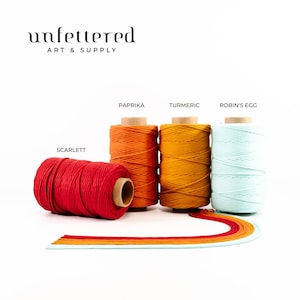 May include: Four spools of cotton cord in different colors: scarlet, paprika, turmeric, and robin's egg blue. The spools are arranged in a row on a white surface. The text "unfettered art & supply" is at the top of the image.