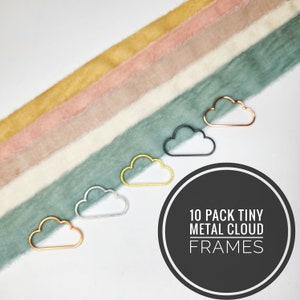 May include: Ten pack of tiny metal cloud frames in gold, silver, rose gold, and black. The frames are arranged in a row on a white surface with a rainbow of fabric behind them. The text "10 PACK TINY METAL CLOUD FRAMES" is written in a circle on the bottom right of the image.