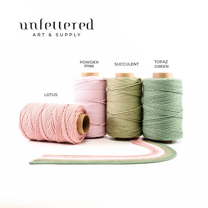 May include: Four spools of cotton cord in different colors: Lotus, Powder Pink, Succulent, and Topaz Green. The spools are arranged in a row on a white background. The text "Unfettered Art & Supply" is at the top of the image.