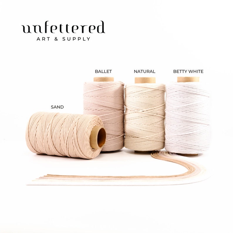 May include: Four spools of natural cotton cord in different shades: sand, ballet, natural, and betty white. The spools are arranged in a row on a white surface. The text "unfettered art & supply" is at the top of the image.