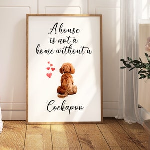 May include: A white framed print featuring a brown and white Cockapoo dog sitting with its back to the viewer. The print reads "A house is not a home without a Cockapoo" with red hearts floating above the dog.