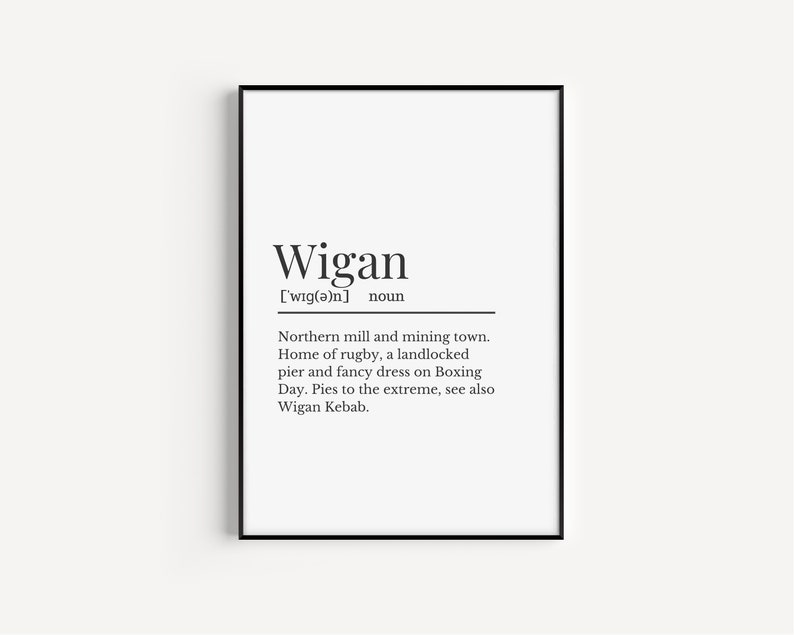 May include: A black and white printable art print with the definition of the word "Wigan" as a northern mill and mining town, home of rugby, a landlocked pier and fancy dress on Boxing Day.  Pies to the extreme, see also Wigan Kebab.