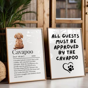 May include: A white sign with black text that reads "ALL GUESTS MUST BE APPROVED BY THE CAVAPOO" with a paw print inside a heart.  The sign is next to a white sign with black text that reads "Cavapoo [kav-uh-pu:] noun A lovable hybrid creature that is 50% cuddles, 50% mischief and 100% adorable. With the intelligence of a poodle and the playfulness of a Cavalier King Charles Spaniel, this furry friend will steal your heart and your socks (literally). Warning: excessive snuggles and slobbery kisses may occur!"  A cartoon image of a brown and white Cavapoo dog is in the top left corner of the sign.