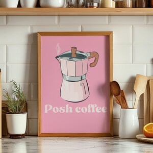 May include: A pink framed print featuring a drawing of a pink and silver coffee pot with steam rising from the spout. The text "Posh coffee" is written in a retro font below the coffee pot.