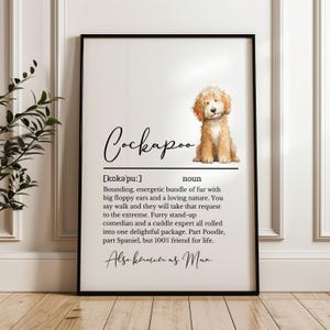 May include: A framed print with a Cockapoo dog illustration. The print includes the breed's name, pronunciation, and a definition describing its characteristics. The text also mentions the dog is also known as Max.