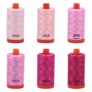 Puede incluir: Seis carretes de hilo rosa y magenta con n&uacute;meros impresos en la parte inferior de cada carrete. Los n&uacute;meros son 2410, 2415, 3660, 2479, 4020 y 1100. El carrete etiquetado como 3660 tambi&eacute;n tiene la palabra "Variegated" impresa.
