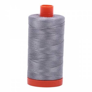 May include: A spool of gray thread with an orange plastic bobbin.