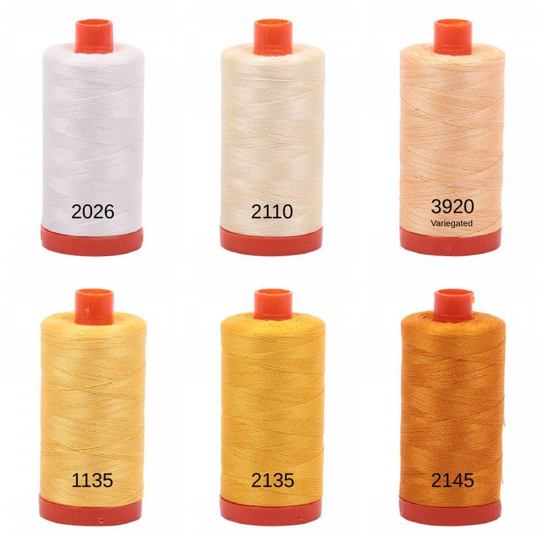 Puede incluir: Seis carretes de hilo en varios tonos de blanco, beige, naranja y amarillo. Los carretes est&aacute;n etiquetados con los n&uacute;meros: 2026, 2110, 3920 (Variado), 1135, 2135 y 2145.