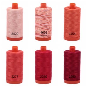 Puede incluir: Seis carretes de hilo en varios tonos de rojo y rosa. Los carretes est&aacute;n etiquetados con los n&uacute;meros: 2420, 4659, 1154, 2277, 2250 y 2260. El carrete etiquetado como 4659 es jaspeado.