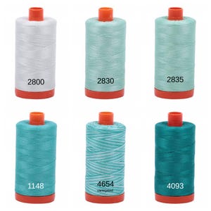 Puede incluir: Seis carretes de hilo en varios tonos de azul y verde. Los carretes est&aacute;n etiquetados con los n&uacute;meros: 2800, 2830, 2835, 1148, 4654 y 4093. Un carrete est&aacute; etiquetado como "variegated".