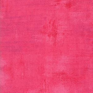 May include: Close-up of a textured fabric in a vibrant pink hue. The material has a distressed look, with visible brushstrokes and colour variations, creating a layered effect. The overall aesthetic is bold and artistic.
