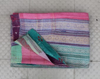 May include: A colorful kantha quilt with pink, green, and purple stripes and patterns. The quilt is folded in half and has a textured, hand-stitched look.