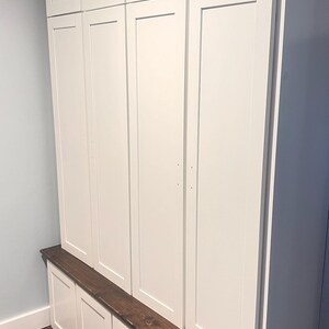 May include: White wooden cabinet with a brown wood top and four doors. The cabinet has three drawers underneath the top.