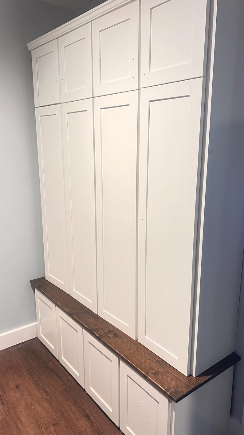 May include: White wooden cabinet with a brown wood top and four doors. The cabinet has three drawers underneath the top.