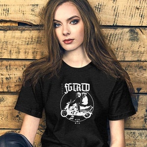 Puede incluir: Una camiseta negra con un gráfico blanco de dos personas conduciendo un scooter. El gráfico incluye el texto "SCREW" sobre el scooter y "OLD MEN" debajo del scooter.