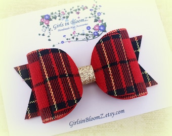 May include: Red and black plaid hair bow with a gold glitter center. The bow is on a white card with the text "Girls in BloomZ Handmade Hair Accessories" and "GirlsinBloomZ.etsy.com".