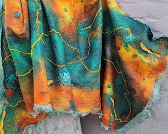 Può includere: Un scialle in lana feltrata a mano con un designo astratto vibrante in tonalità di arancio, giallo e turchese. Lo scialle ha un bordo a frange ed è decorato con cuciture gialle.