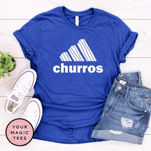 May include: A royal blue t-shirt with a white graphic of a stylized mountain range with the word "churro" printed below it.