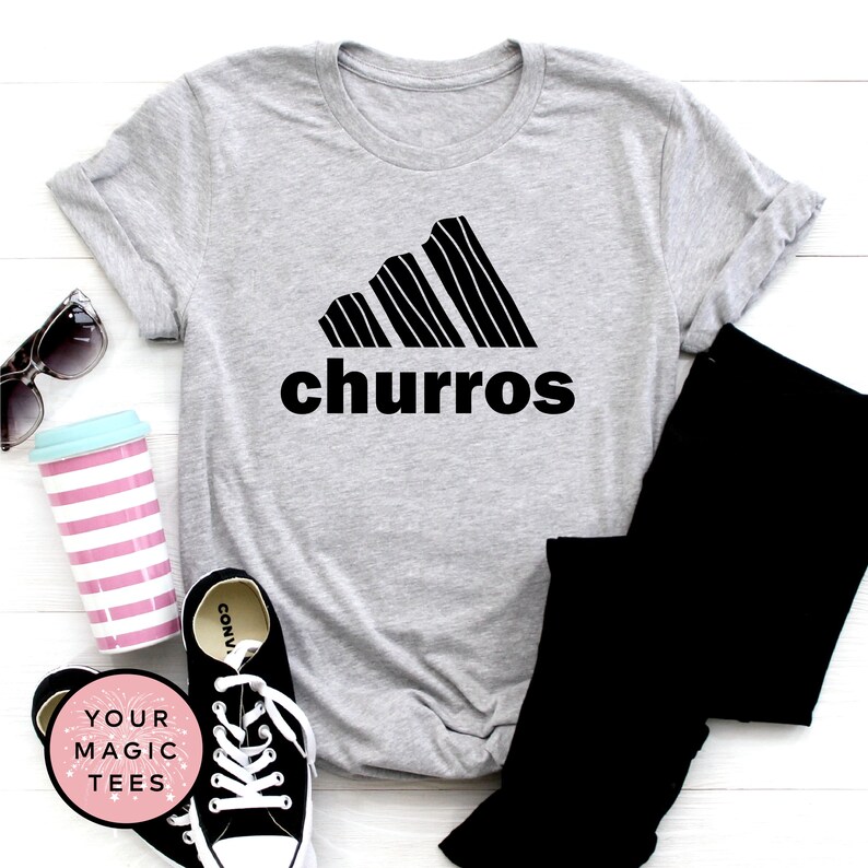 May include: Gray t-shirt with a black graphic of a churro-shaped Adidas logo and the word "churro" printed below.