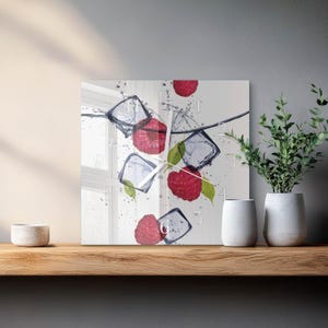 May include: Square wall clock with a design of raspberries, ice cubes, and water splashes. The clock face has white numerals and hands. The image creates a refreshing, summery feel, suitable for kitchen or dining room decor.