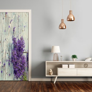 Puede incluir: Un primer plano de un ramo de flores de lavanda sobre un fondo de madera azul claro desgastado. Las flores son de un morado vibrante y están dispuestas en un estilo rústico y natural.
