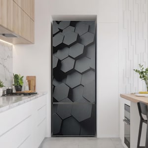 May include: A refrigerator with a black and gray geometric design. The design features a pattern of three-dimensional hexagons. The refrigerator is in a modern kitchen with white cabinets and a marble countertop.