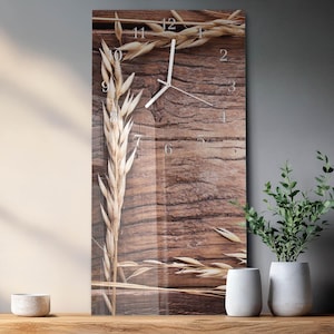 May include: A rectangular wall clock with a wooden background and wheat stalks. The clock face has silver-colored hands and numerals. The clock is approximately 12 inches wide and 24 inches tall.