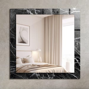 Peut inclure: Un miroir encadré de marbre noir et blanc reflétant l'intérieur d'une chambre à coucher. Le miroir a un design élégant et moderne et ajouterait une touche d'élégance à n'importe quelle pièce.