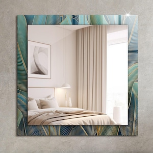 Puede incluir: Un espejo rectangular con un marco decorativo con un patrón de hojas azules y doradas. El espejo refleja un interior de dormitorio con una cama, cortinas y una ventana.