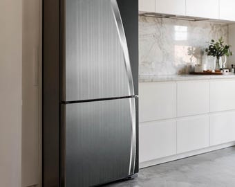 May include: A stainless steel refrigerator with a brushed metal finish. The two-door appliance has a sleek, modern design with a vertical accent on the right side. The refrigerator is in a kitchen setting with white cabinets and a marble countertop.