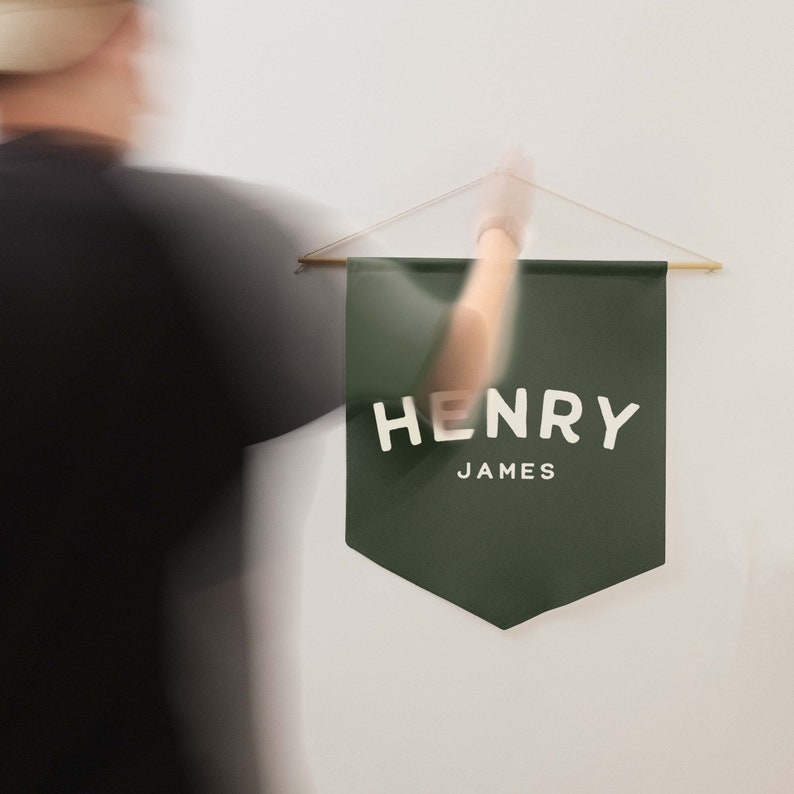 a pine coloured pennant banner that you can customise with a name, being held by a man