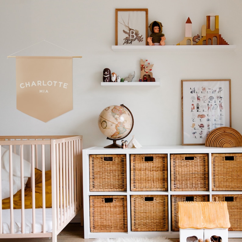 a dusty pink coloured banner in a neutral style nursery. You can personalise this with any name