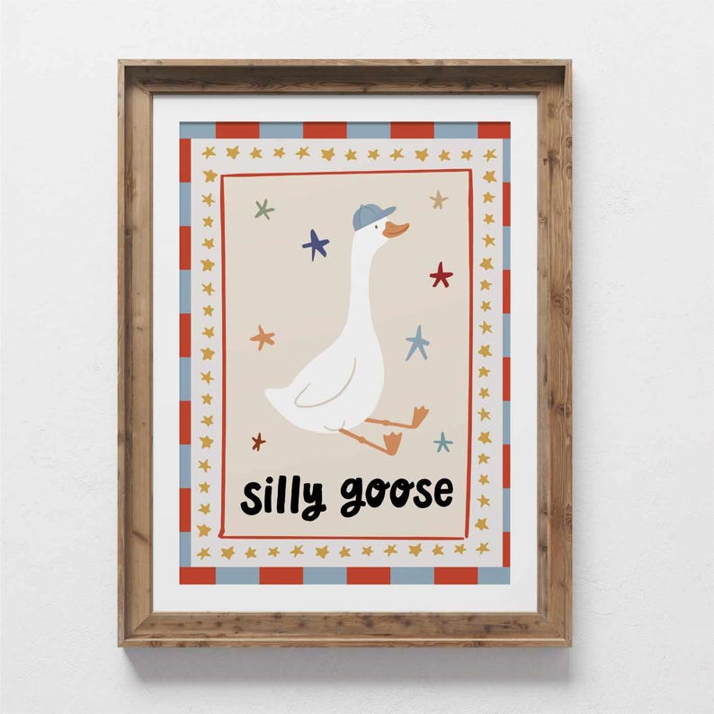May include: A framed print featuring a whimsical illustration of a white goose wearing a blue cap, with the words "silly goose" in black. The artwork is surrounded by a red, white, and blue border with star accents, perfect for a nursery or child's room.