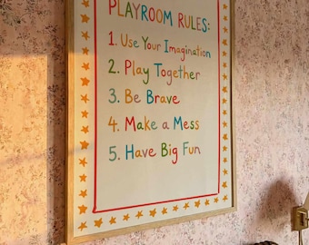 May include: A framed sign with the words "PLAYROOM RULES" in colorful letters. The rules are: Use Your Imagination, Play Together, Be Brave, Make a Mess, and Have Big Fun. The frame is light brown with orange stars.