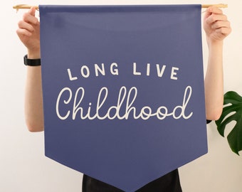 May include: A blue banner with the text "LONG LIVE CHILDHOOD" in white lettering.