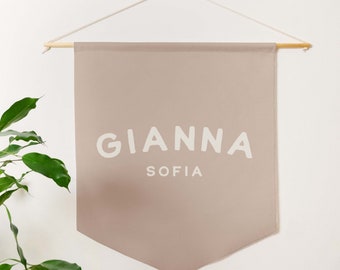 May include: A light brown fabric banner with the name "Gianna Sofia" printed in white.