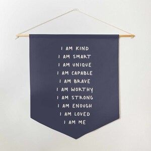 May include: A navy blue banner with white text that reads "I am kind, I am smart, I am unique, I am capable, I am brave, I am worthy, I am strong, I am enough, I am loved, I am me".