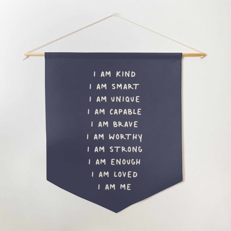 May include: A navy blue banner with white text that reads "I am kind, I am smart, I am unique, I am capable, I am brave, I am worthy, I am strong, I am enough, I am loved, I am me".