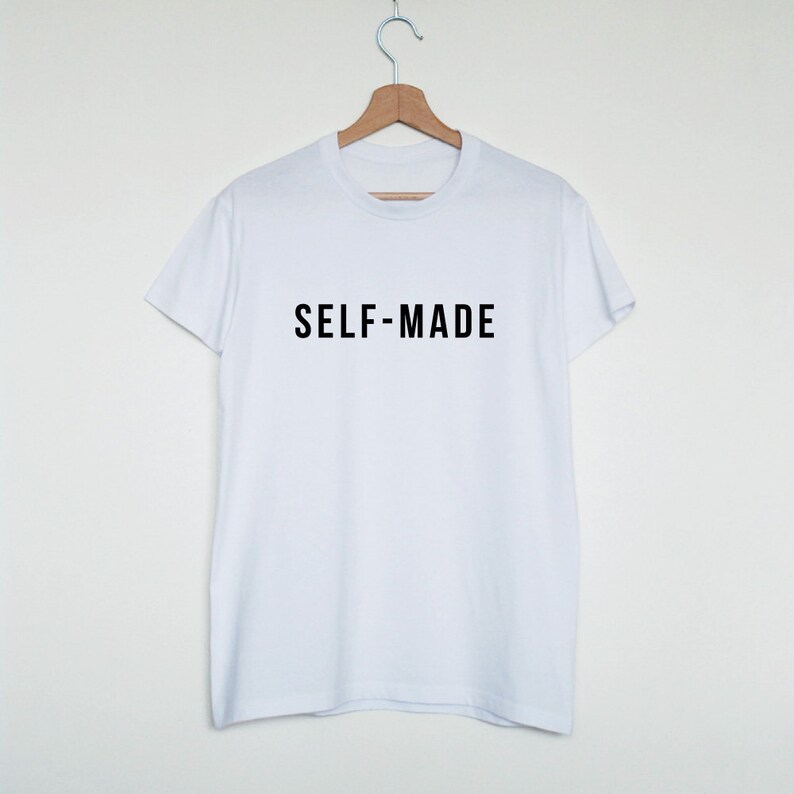 Puede incluir: Camiseta blanca con texto negro que dice "SELF-MADE" sobre un fondo blanco.