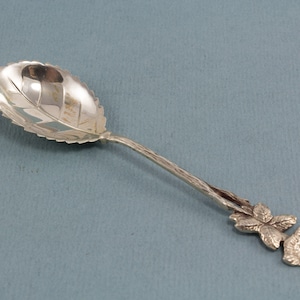 Silver sugar spoon with a rose pattern