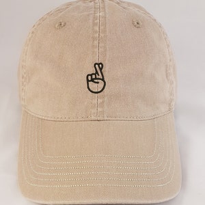 Fingers Crossed Emoji or Good Luck Sign. A fashionable, soft and beautifully embroidered hat or baseball cap.