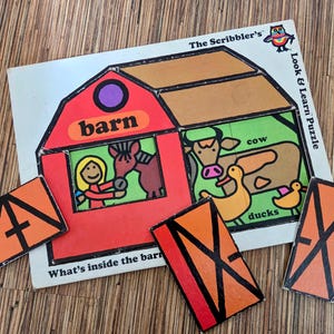 May include: A children's puzzle with a barn theme. The puzzle features a red barn with a brown roof, a cow, ducks, and a horse. The puzzle pieces are orange with black lines. The text "The Scribbler's Look & Learn Puzzle" is visible.