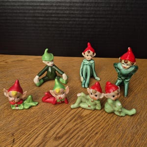 Elija entre una variedad de elfos, duendes y duendes de cerámica en verde.