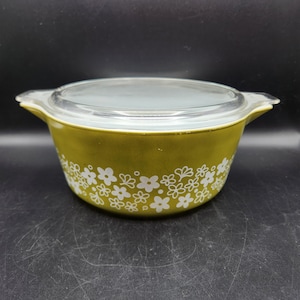 以下が含まれることがあります： 白い花柄の緑色のキャセロール皿と透明なガラスの蓋