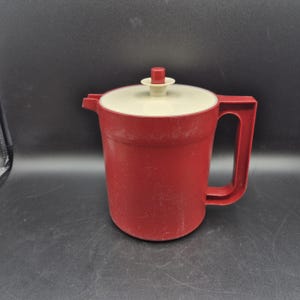 Brocca Tupperware da 1,5 litri color rosso paprika con coperchio a pulsante.
